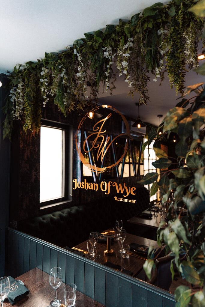 Joshan of Wye logo sign with greenery above dining table, Ashford